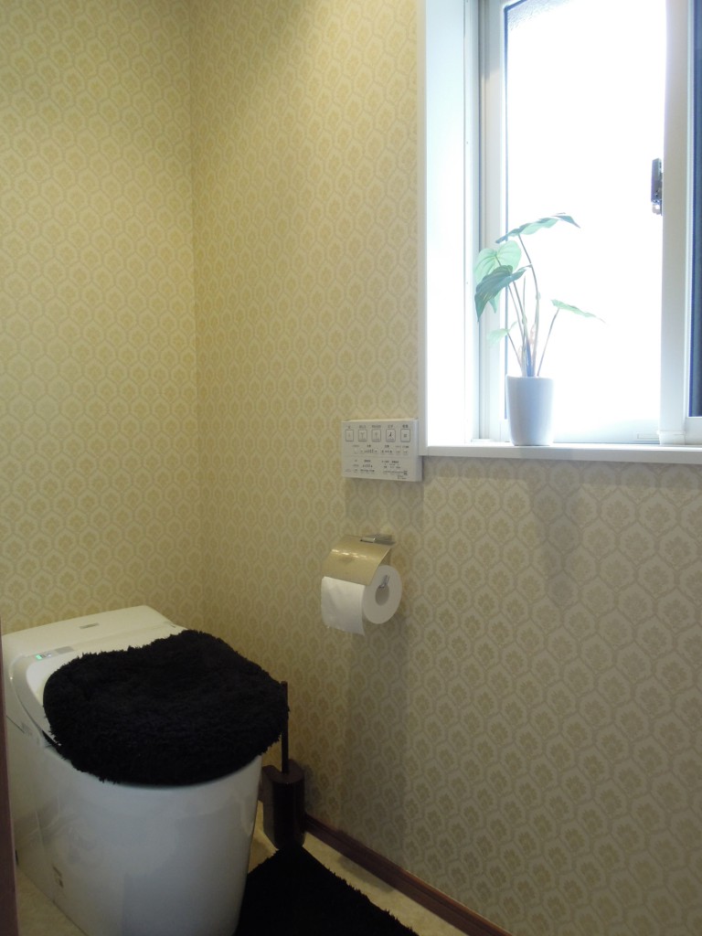 トイレはゴールドのクロスにし明るくなるようにした。手洗器の上に鏡をつけてこだわりの空間が完成した。